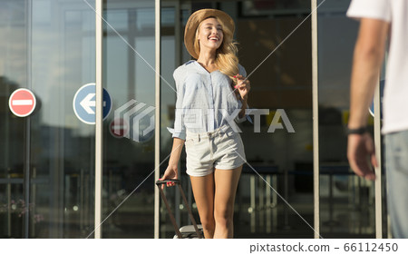 Boyfriend picking up his girl near airport building 66112450
