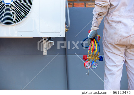 Air conditioning repairman carrying tools, gauges 66113475