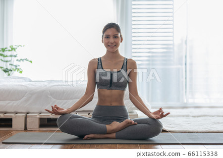 Attractive Asian Woman Practice Yoga Pose To Meditation in Bedroom