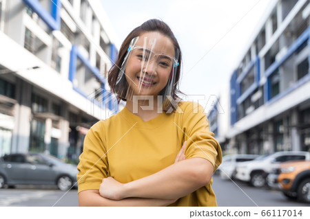woman wearing face shield standing in the street, COVID- 19 woman wearing face shield standing in the street, COVID- 19 66117014