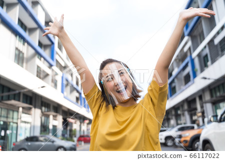 woman wearing face shield standing in the street, COVID- 19 66117022