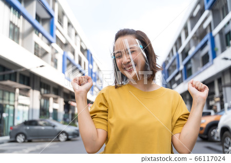 woman wearing face shield standing in the street, COVID- 19 woman wearing face shield standing in the street, COVID- 19 66117024