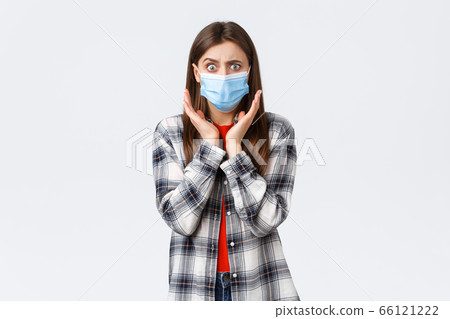 Coronavirus outbreak, leisure on quarantine, social distancing and emotions concept. Concerned and shocked young woman hear bad news. Girl in medical mask gasping and looking worried camera Coronavirus outbreak, leisure on quarantine, social distancing and emotions concept. Concerned and shocked young woman hear bad news. Girl in medical mask gasping and looking worried camera 66121222