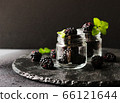 ripe blackberries in a glass jar, breakfast on a 66121644