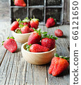 red ripe strawberry in a wooden bowl on a rustic 66121650