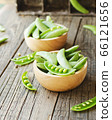 green peas in a wooden bowl on a rustic table, 66121656