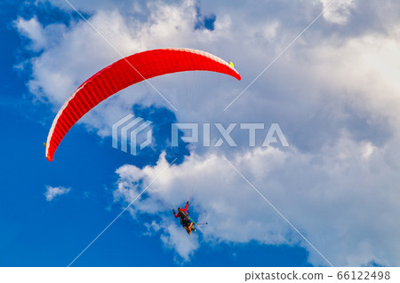 Flying paraglider on a blue sky with clouds. Flying paraglider on a blue sky with clouds. 66122498