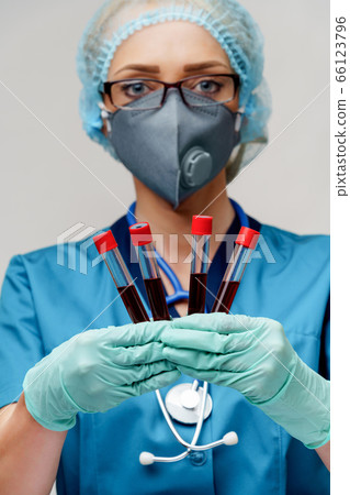 medical doctor nurse woman wearing protective mask and gloves - holding virus blood test tube medical doctor nurse woman wearing protective mask and gloves - holding virus blood test tube 66123796
