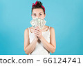 A young woman peeks out for the dollars she holds 66124741