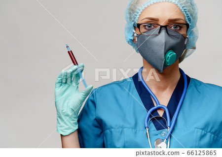 medical doctor nurse woman wearing protective mask and gloves - holding syringe medical doctor nurse woman wearing protective mask and gloves - holding syringe 66125865