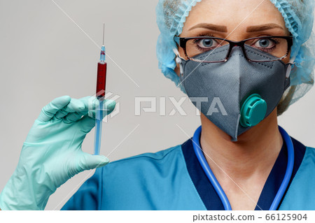 medical doctor nurse woman wearing protective mask and gloves - holding syringe 66125904