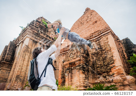 Father and Toddler Son tourists in Vietnam. Dad throws up his . Po Nagar Cham Tovers. Asia Travel concept. 66128157