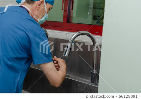 Male surgeon is washing his hands in a hospital Male surgeon is washing his hands in a hospital 66129091