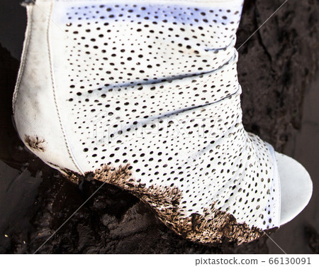 Dirty white high-heel shoe in the mud Dirty white high-heel shoe in the mud 66130091