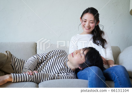 Young man sleeping on female knee pillow 66131104