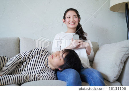 Man sleeping on knee pillow and woman thinking with smartphone Man sleeping on knee pillow and woman thinking with smartphone 66131106