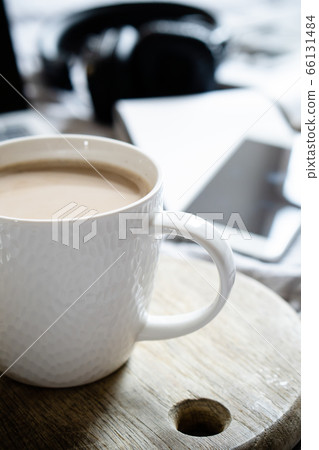 Real home workplace, laptop with cup of coffee with cookies on bed with cozy blanket 66131484