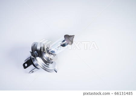 One new halogen light with an H4 cinder on a grey gradient background. New car parts for external car lighting systems 66131485