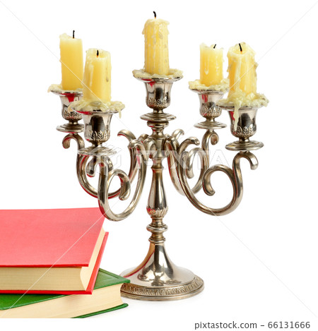 Candlestick with candles and book isolated on 66131666