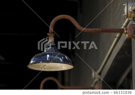 Old black lamp is attached to the wall. 66131836