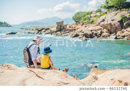 Father and son travelers at the Hon Chong cape, Garden stone, popular tourist destinations at Nha Trang. Vietnam Father and son travelers at the Hon Chong cape, Garden stone, popular tourist destinations at Nha Trang. Vietnam 66132748