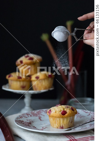 The moment when the powdered sugar is sprinkled on the muffin The moment when the powdered sugar is sprinkled on the muffin 66133156