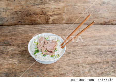 A bowl of Traditional Vietnamese beef soup Pho Bo at the dark old wooden background 66133412