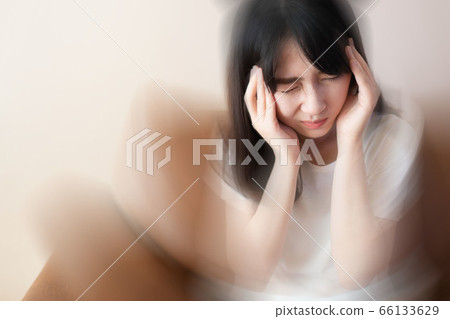 Young female suffering from dizziness, vertigo, headache while sitting on couch at home. Cause of dizzy inclued migraine, stress, stroke, Meniere disease or brain tumor. Health care problem. Young female suffering from dizziness, vertigo, headache while sitting on couch at home. Cause of dizzy inclued migraine, stress, stroke, Meniere disease or brain tumor. Health care problem. 66133629