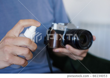 man disinfecting his camera man disinfecting his camera 66134053
