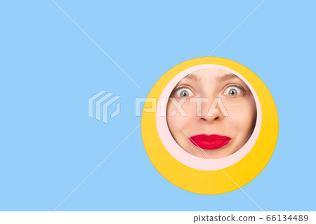 Female face with red lips peeking throught circle in blue background Female face with red lips peeking throught circle in blue background 66134489