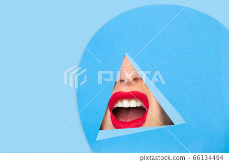 Female red lips peeking throught triangle in blue background Female red lips peeking throught triangle in blue background 66134494