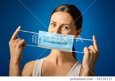 woman in white shirt shows how to wear a mask during a pandemic woman in white shirt shows how to wear a mask during a pandemic 66136315