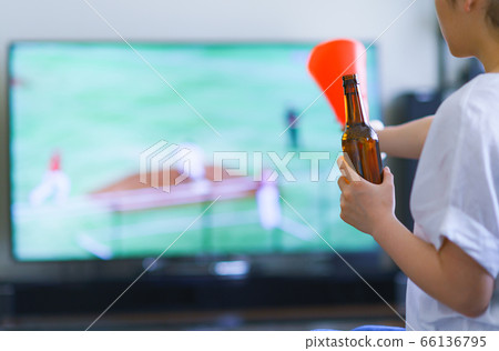 Image of a young woman watching sports at home on TV [Professional baseball video distribution service] 66136795