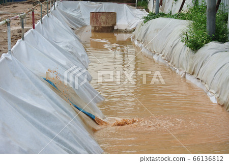 MALACCA, MALAYSIA -OCTOBER 26, 2015: Check dam or silt trap at the construction site. Soil and mud from the construction site in strained and precipitated. Only clean water discharged. MALACCA, MALAYSIA -OCTOBER 26, 2015: Check dam or silt trap at the construction site. Soil and mud from the construction site in strained and precipitated. Only clean water discharged. 66136812
