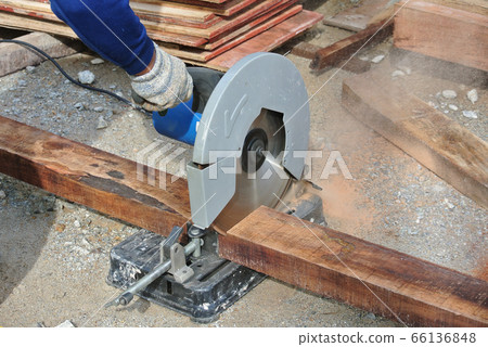 MALACCA, MALAYSIA -APRIL 25, 2016: Carpenter using the electrically powered circular saw to cut plywood at the construction site in Malacca, Malaysia.  66136848