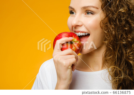 Pretty curly girl with red apple Pretty curly girl with red apple 66136875
