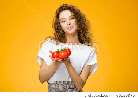 Pretty caucasian girl with curly hair holding red Pretty caucasian girl with curly hair holding red 66136879
