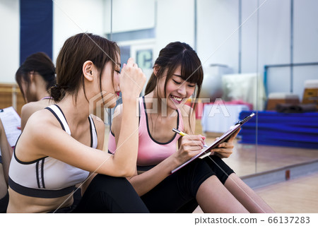 Young woman checking fitness gym training content 66137283