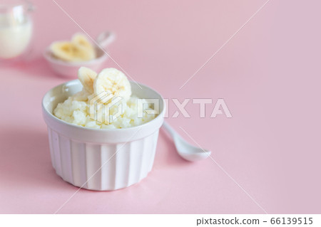 Milk rice porridge with banana in a white mask on a pink background, can be used for article, banner and infographic. 66139515