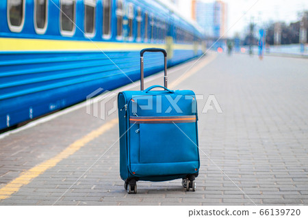 Suitcase on the platform next to the train station. Empty platform, epidemic, suspension of railway traffic 66139720