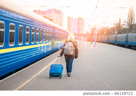 Woman traveler tourist walking with luggage at train station, copy space Woman traveler tourist walking with luggage at train station, copy space 66139723