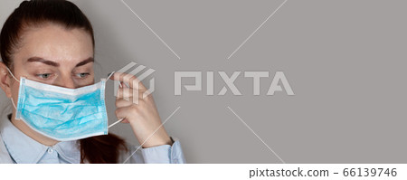 Young girl in a medical mask feels bad. Sore throat, illness. Coronavirus, covid 19 with copyspace Young girl in a medical mask feels bad. Sore throat, illness. Coronavirus, covid 19 with copyspace 66139746