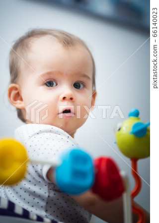 One year old baby sits in walker with colorful One year old baby sits in walker with colorful 66140023