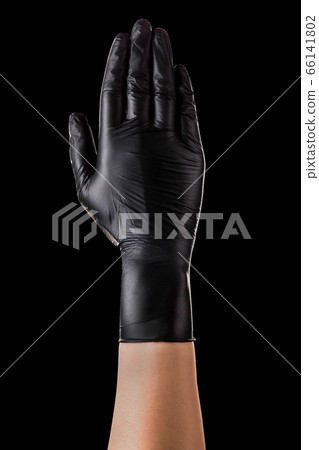Hand in black gloves showing five fingers and palm isolated on black background 66141802