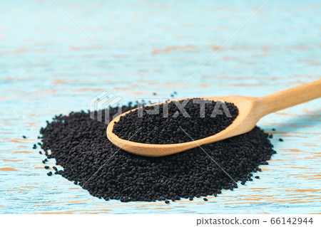 organic seeds of black cumin in a wooden spoon  on 66142944