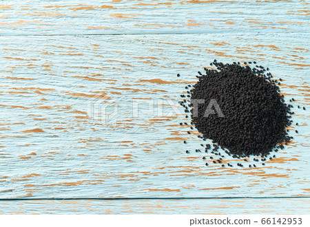 black cumin on a blue wooden table, top view with 66142953