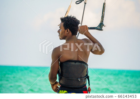 Young Attractive Muscular and Strong Athletic Black African Man Kite Surfing Instructor Teacher at the White Sand Beach Young Attractive Muscular and Strong Athletic Black African Man Kite Surfing Instructor Teacher at the White Sand Beach 66143453
