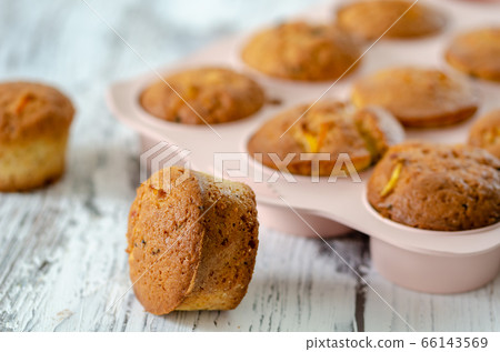 Delicious muffin with orange on a wooden table. Delicious muffin with orange on a wooden table. 66143569