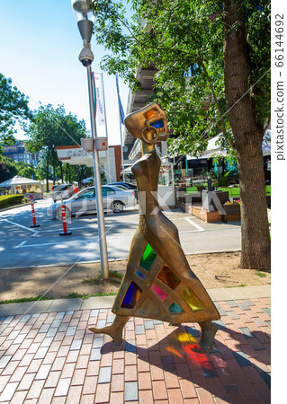 Sculpture of woman from yellow metall and colored 66144692