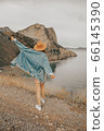 Beautiful girl in a hat on a summer vacation in the mountains on nature. Blue sky and sea. 66145390